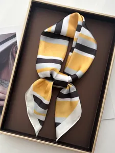 Detailed view of striped silk scarf tied in a bow on a luxury metal display tray