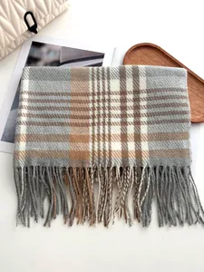 Détail des franges de l'écharpe à carreaux et texture tissée douce beige et gris
