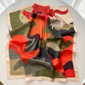 Close-up of printed silk square scarf with floral pattern and high-gloss satin texture