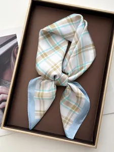 Detail of elegant plaid square silk scarf with light blue trim on a presentation tray