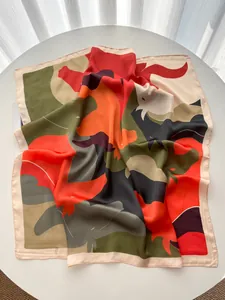 Macro detail of silk-like square scarf featuring abstract colorful patterns and smooth texture