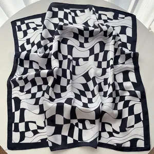 Detail of premium black and white geometric silk scarf with checkerboard and wave patterns