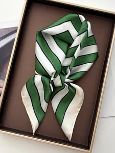 Detail of green and white striped silk scarf with satin finish on display tray