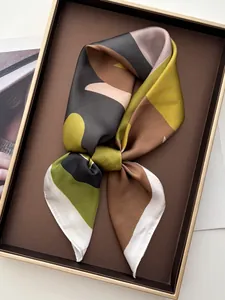 Macro view of abstract silk scarf with geometric patterns in deep green and brown tones