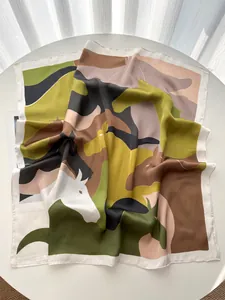 Detail of silk satin square scarf featuring abstract horse print in olive and camel
