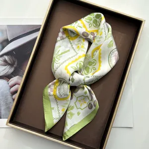 Detail of silk square scarf featuring tropical palm and sardine prints in a luxury tray