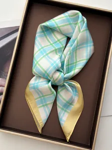 Detail of checkered silk scarf in green, blue and white on dark wooden tray