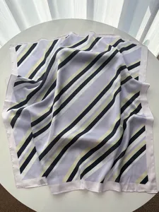 Detailed view of striped satin square scarf in lilac and black on a white table