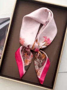 Detailed view of floral silk scarf with pink pattern in a premium gift box