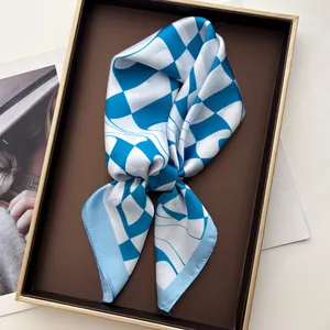 Elegant geometric blue and white checkered silk scarf styled in a premium display tray