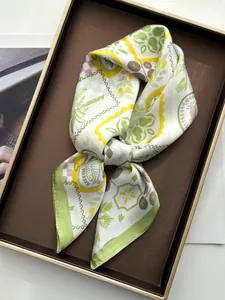 Detailed view of green coconut palm silk scarf with sardine print in a premium gift box