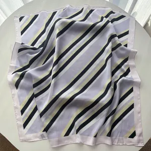 Close-up of a striped silk square scarf with purple and navy bands on a white surface