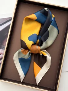 Detail of silk-like square scarf with geometric patterns in a premium gift display box