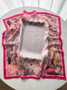 Detail of floral silk scarf showing vibrant rose and lavender prints on satin fabric