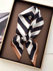Detail of striped silk square scarf with geometric V-pattern inside a premium gift box