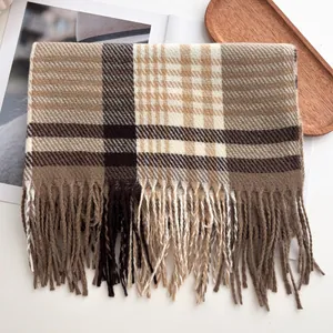 Gros plan sur la texture du foulard à carreaux avec détails de franges et motifs marron