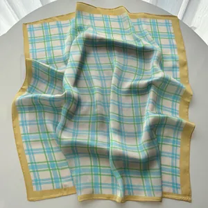 Detailed close-up of plaid silk scarf featuring yellow borders and satin texture folds
