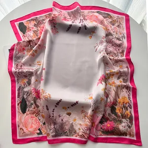 Detail of floral print silk scarf with satin texture and vibrant fuchsia border