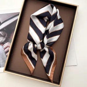 Close-up of a striped satin silk scarf tied neatly in a premium gift box