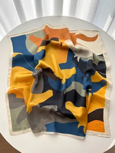 Detail view of artistic geometric print silk scarf with polished satin finish texture