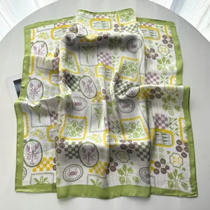 Detail view of the elegant silk-like square scarf featuring sea life and palm tree prints