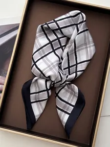 Close-up of black and white checkered silk scarf texture and elegant box packaging
