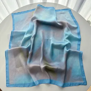 Vue détaillée d'un foulard en soie élégant avec dégradé et bordure bleu ciel