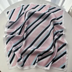 Detail of a square silk scarf with pastel stripes and premium satin texture on display