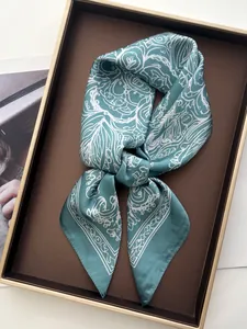 Detail of silk satin scarf with vintage white floral prints in a luxury gold-rimmed tray