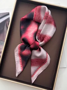 Macro shot of abstract leopard silk scarf in red and black shades inside a luxury gift box