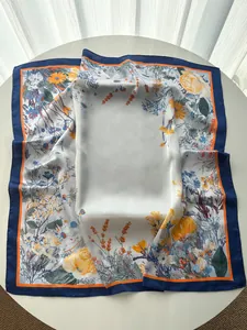 Close-up of floral print silk scarf with elegant drape and deep blue border detail