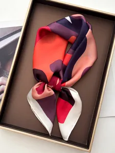 Detailed view of luxury printed silk scarf with abstract patterns in a display tray