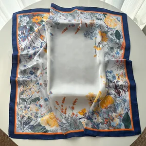 Detail of square silk scarf with yellow roses and lavender floral patterns on white silk