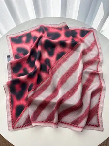 Detail of leopard and stripe patterned silk scarf with premium texture and pink hem edges