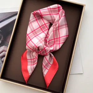 Detail of red checkered silk scarf tied in a bow on a luxury tray for elegant styling
