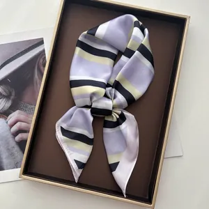 Elegant striped silk square scarf with purple and beige patterns in a gift tray