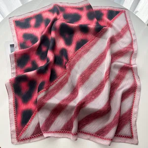 Detail of silk square scarf featuring pink leopard print and diagonal stripe patchwork