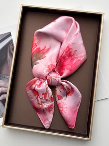 Dettaglio di un foulard in seta rosa con motivo floreale in una scatola regalo di lusso