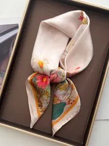 Detailed view of pink floral silk scarf with satin finish on elegant leather tray