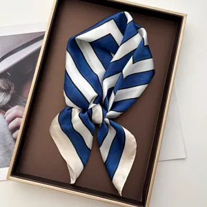 Close-up of blue and white striped silk square scarf with satin finish in a gift box