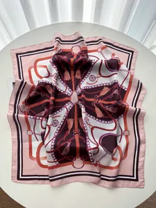 Close-up of silk scarf with baroque tassels and chain patterns on a satin texture