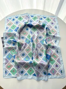 Détail d'un élégant carré de soie avec imprimé tropical vintage et bordure bleu clair