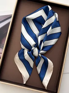 Detailed close-up of striped silk neckerchief inside an elegant gold-rimmed gift box