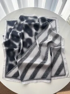 Macro detail of leopard print and striped silk scarf featuring premium hemmed edges