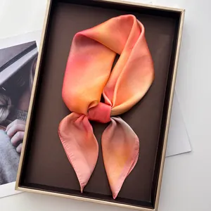 Détail d'un carré de soie avec dégradé de couleurs présenté dans un coffret cadeau