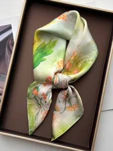 Vista dettagliata di un foulard in seta floreale piegato in una confezione regalo premium