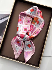 Gros plan d'un foulard en soie avec motifs tropicaux posé dans un plateau doré chic