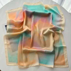 Détail de la texture en soie lisse et du dégradé coloré sur le foulard carré élégant