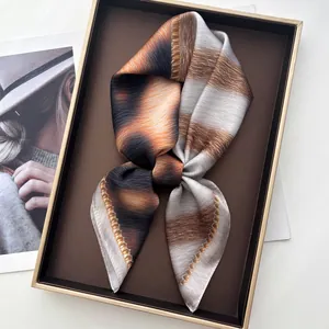 Detail of silk scarf with leopard gradient pattern and brushstroke texture on tray