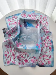 Dettaglio foulard in seta con stampe di rose su tessuto satinato sfumato azzurro